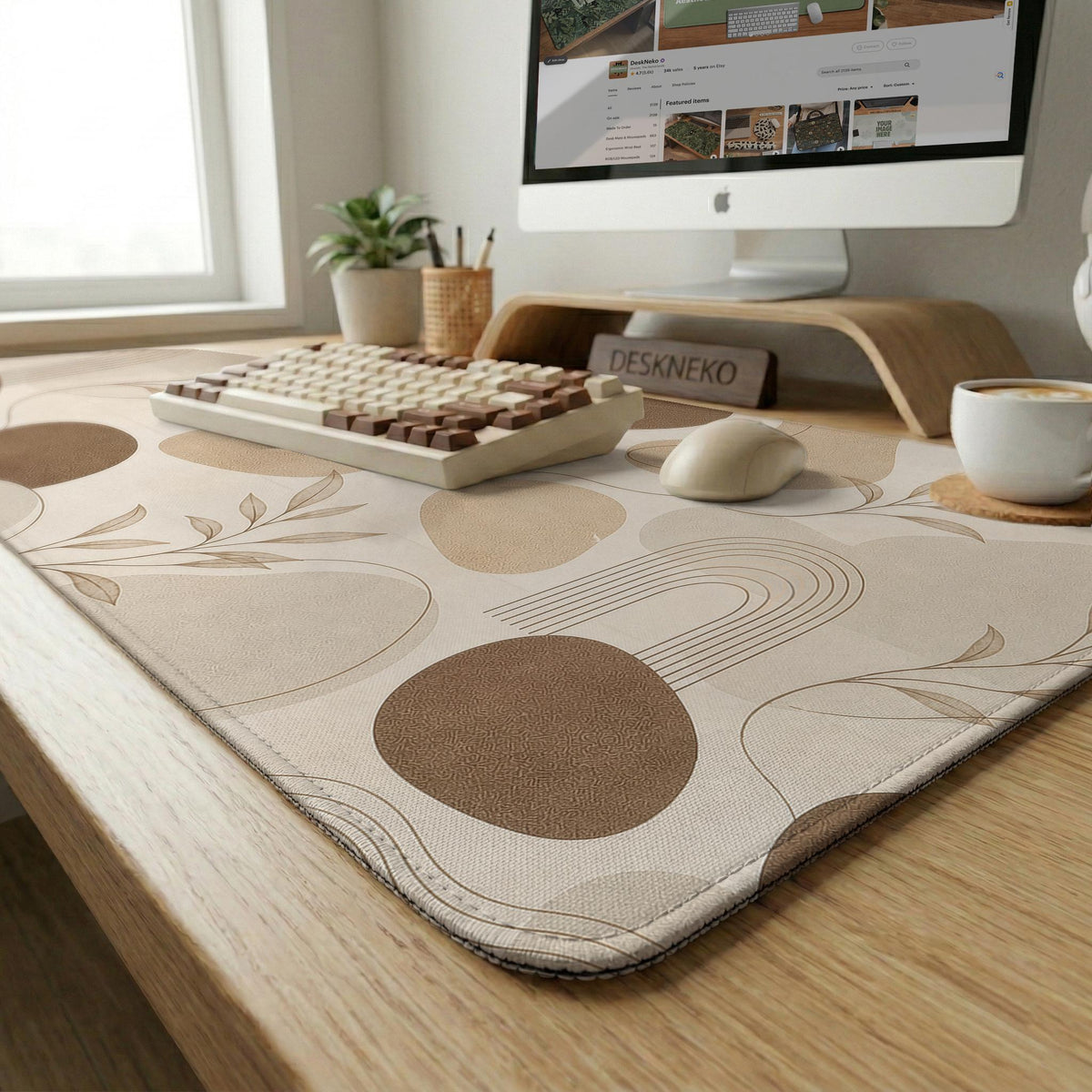 Beige desk mat with fine botanical line drawings and soft abstract shapes on a light neutral background.