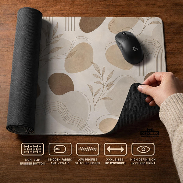 Beige desk mat with fine botanical line drawings and soft abstract shapes on a light neutral background.