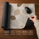 Beige desk mat with fine botanical line drawings and soft abstract shapes on a light neutral background.