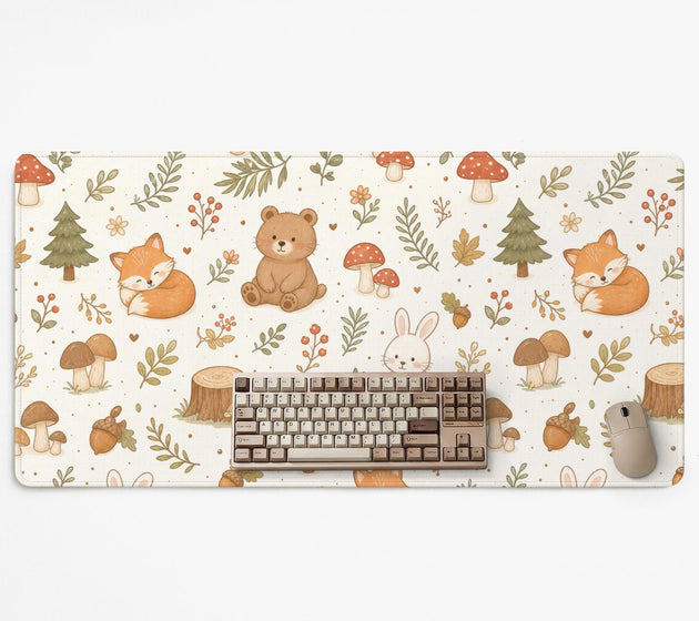Cream desk mat with a woodland animal pattern featuring foxes, bunnies, mushrooms, berries, acorns, and sage leaves in soft green tones.