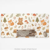 Cream desk mat with a woodland animal pattern featuring foxes, bunnies, mushrooms, berries, acorns, and sage leaves in soft green tones.