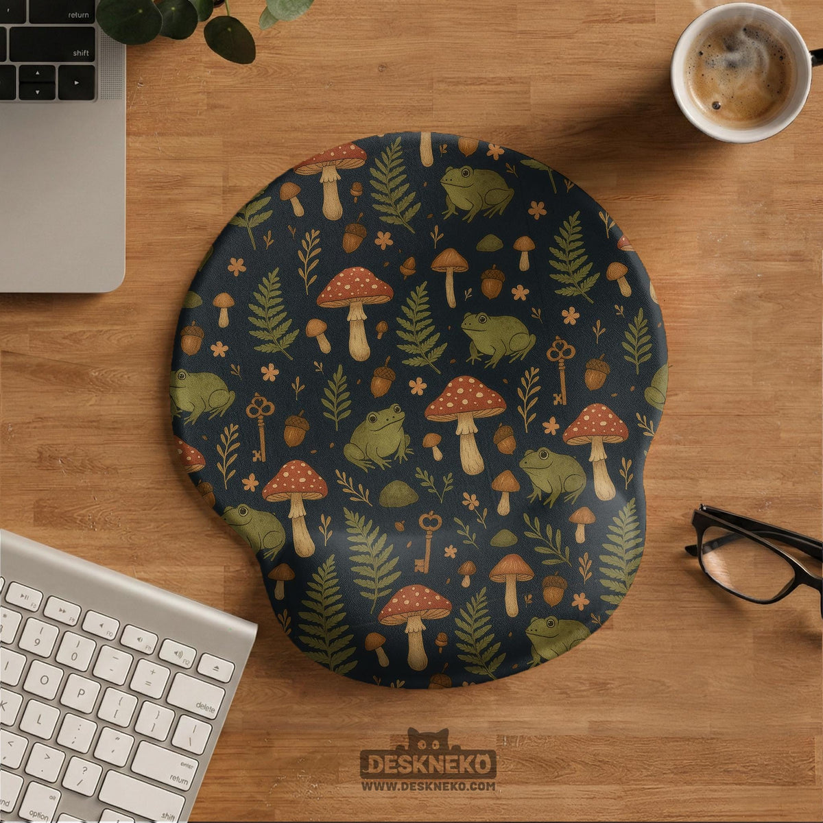 Dark botanical desk mat options with frogs, mushrooms, ferns, and acorns in brown and green tones, plus a matching keyboard wrist rest.