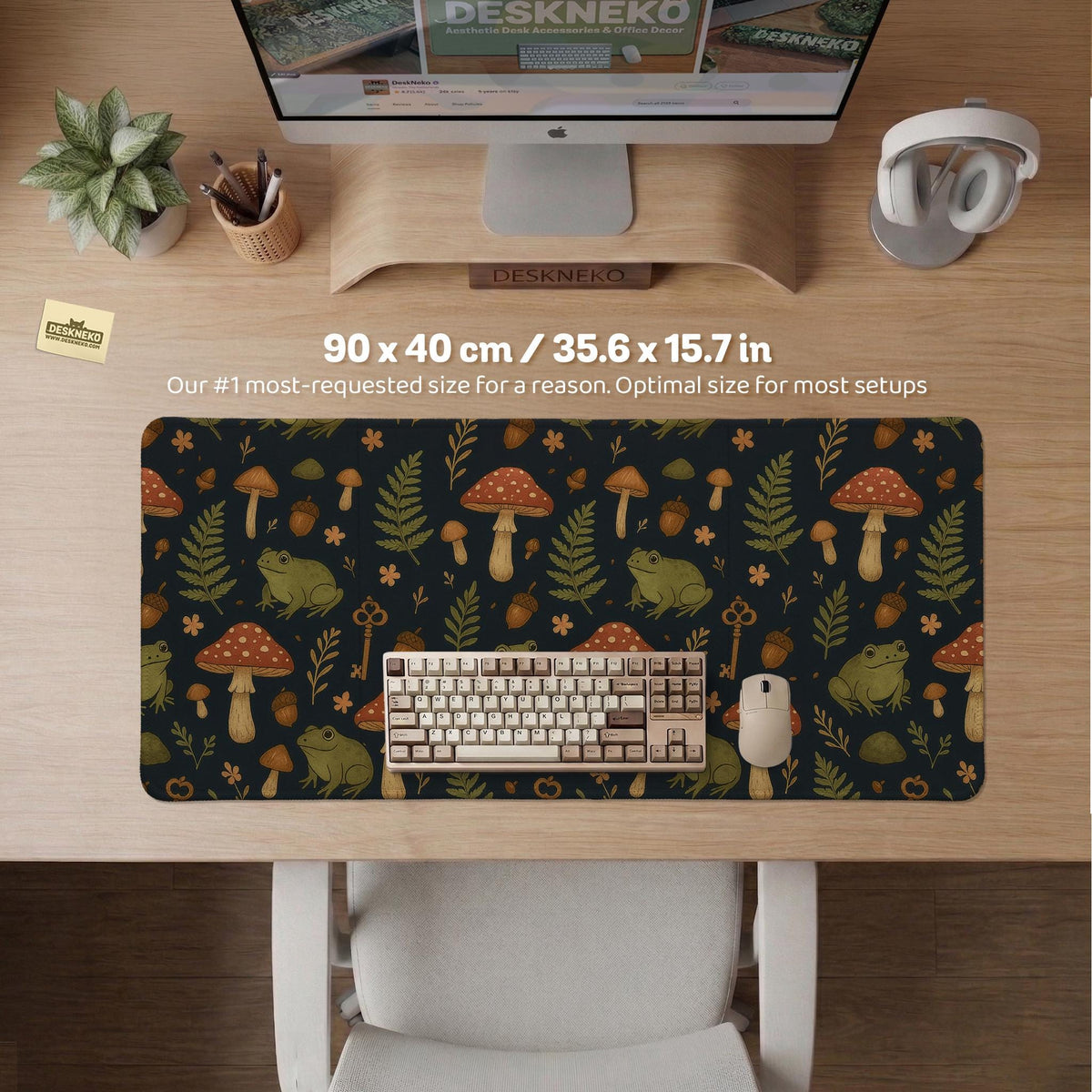 Dark forest-themed desk mat with an all-over pattern of frogs, mushrooms, fern leaves, acorns, tiny flowers, and antique keys.