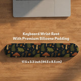 Dark forest-themed desk mat with an all-over pattern of frogs, mushrooms, fern leaves, acorns, tiny flowers, and antique keys.