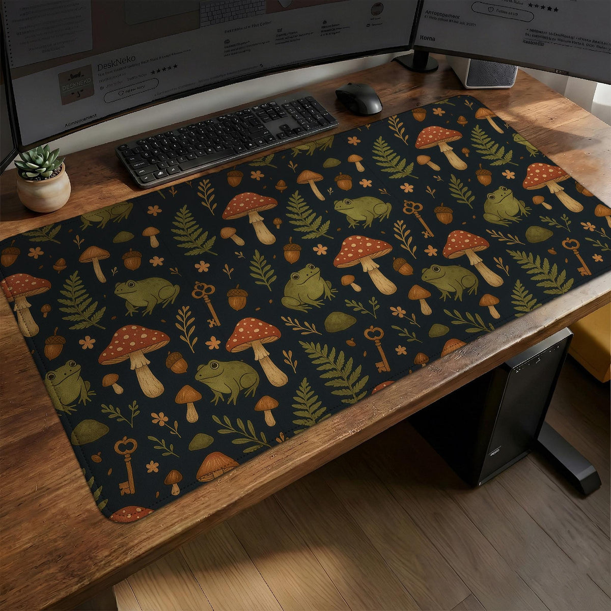 Dark forest-themed desk mat with an all-over pattern of frogs, mushrooms, fern leaves, acorns, tiny flowers, and antique keys.