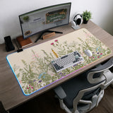 A desk mat with a botanical meadow design featuring wildflowers, leafy stems, and soft neutral colors.