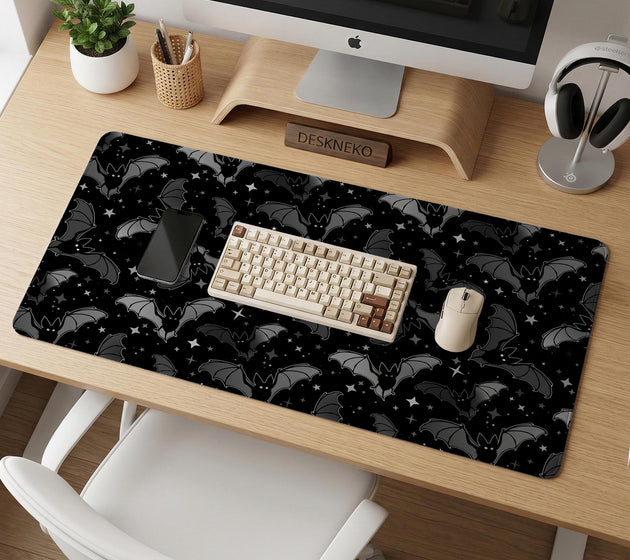 Black desk mat with a dark bat pattern and scattered stars on a charcoal background.