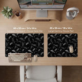 Black desk mat with a dark bat pattern and scattered stars on a charcoal background.