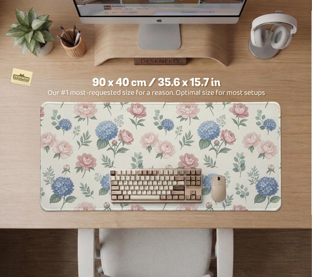 Floral desk mat with sage greenery, pink peonies, blue flowers, and a warm cream background.