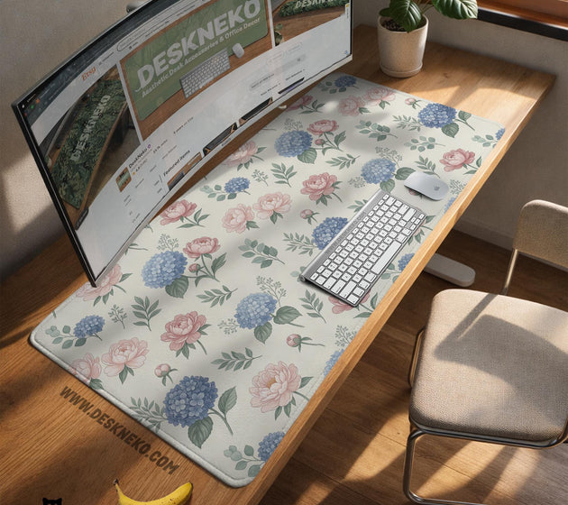 Floral desk mat with sage greenery, pink peonies, blue flowers, and a warm cream background.