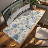 Floral desk mat with sage greenery, pink peonies, blue flowers, and a warm cream background.