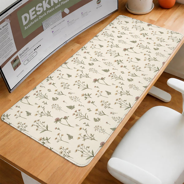 Desk mat with a sage green background, tiny wildflowers, and a vintage botanical floral pattern.