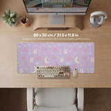 Pastel lavender desk mat with an all-over pattern of bunnies, crescent moons, clouds, bows, stars, and small flowers.