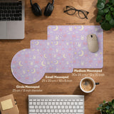 Lavender desk mat with an all-over pattern of bunny faces, clouds, moons, bows, and flowers in pastel colors.