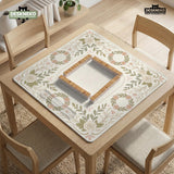 Square mahjong mat with a light floral border in sage green, cream, and blush around a plain center play area.