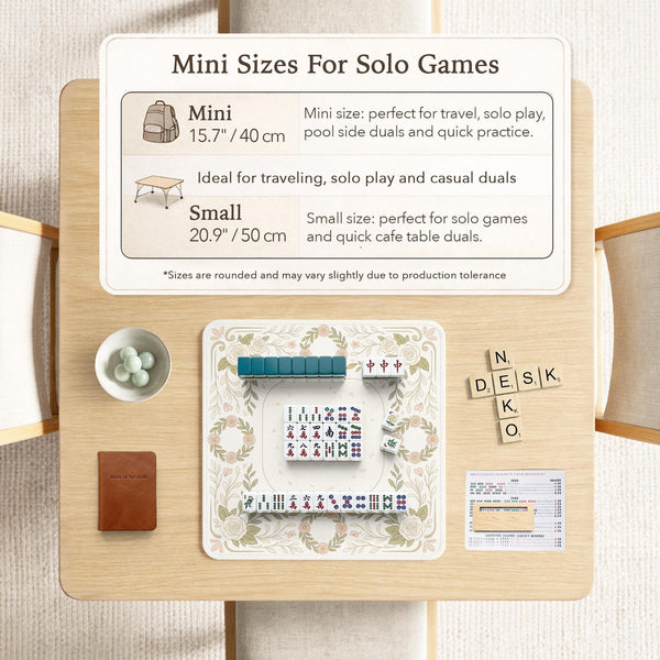 Square mahjong mat with a light floral border in sage green, cream, and blush around a plain center play area.