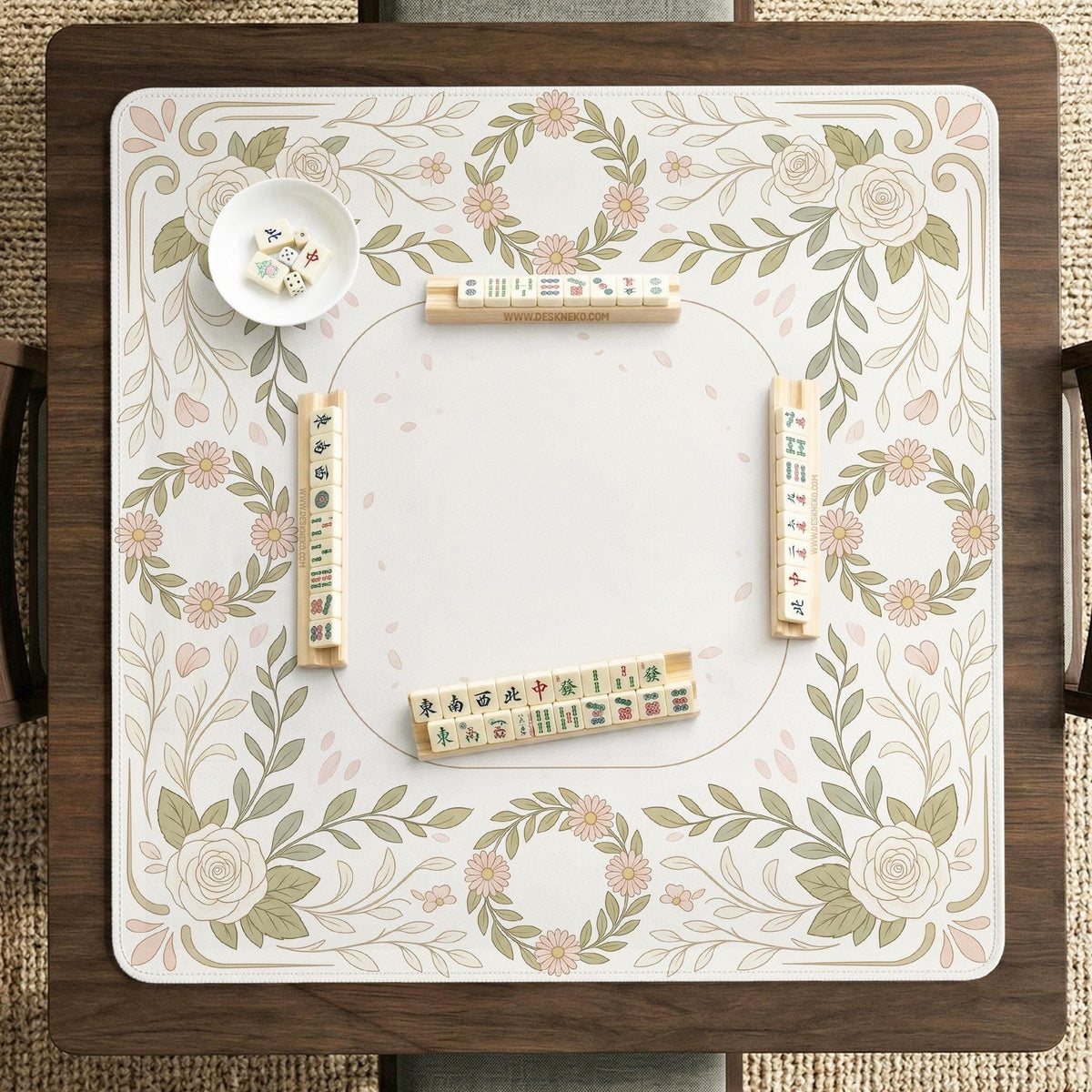 Square mahjong mat with a light floral border in sage green, cream, and blush around a plain center play area.