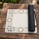 Square mahjong mat with a light floral border in sage green, cream, and blush around a plain center play area.