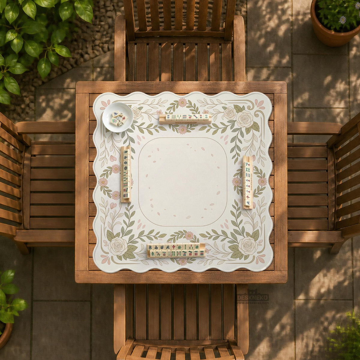 Square mahjong mat with a light floral border in sage green, cream, and blush around a plain center play area.