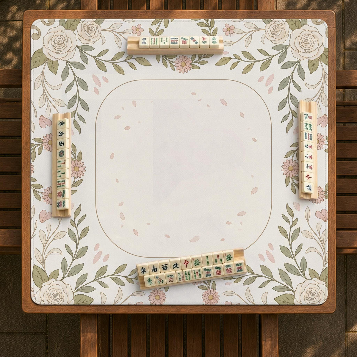 Square mahjong mat with a light floral border in sage green, cream, and blush around a plain center play area.
