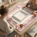 Pink gingham mahjong mat with a floral border, cherry blossom details, and a bow design around a plain center play area.