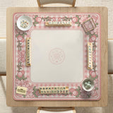 Square pink mahjong mat with a gingham border, floral corner details, and ribbon accents on a light background.