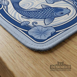 Blue and white square mahjong mat with a koi fish and lotus border design and a plain center area.
