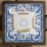 Blue and white square mahjong mat with a koi fish and lotus border design and a plain center area.