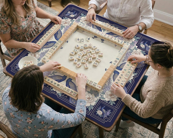 Blue mahjong table mat with a peacock and floral border, ivory center, lavender flowers, and scalloped edges.