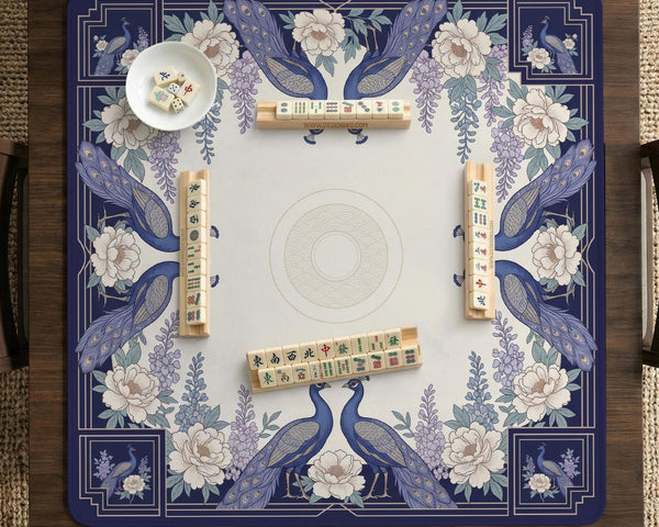Blue mahjong table mat with a peacock and floral border, ivory center, lavender flowers, and scalloped edges.