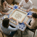 Square blue and white mahjong mat with peonies, cranes, pagoda accents, and chinoiserie linework around a plain center.