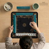 Black mahjong table mat with a gold dragon border, gold geometric corner details, and a clear center play area.