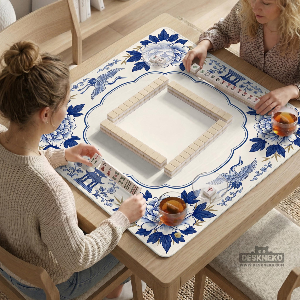 Blue and white mahjong mat with cranes, floral porcelain-style artwork, a cream center area, and a decorative border.