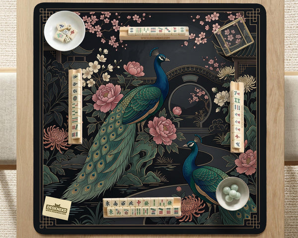 Square black mahjong mat with a gold peacock, blush flowers, and dark botanical artwork on a dark background.