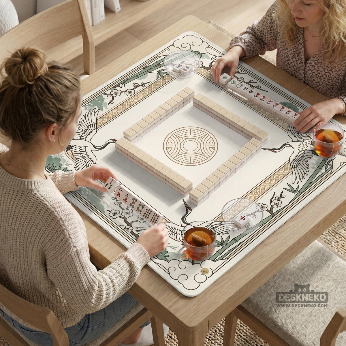Square mahjong table mat with a cream center and a border design of cranes, bamboo, plum blossoms, and a geometric frame in sage green and warm gold.