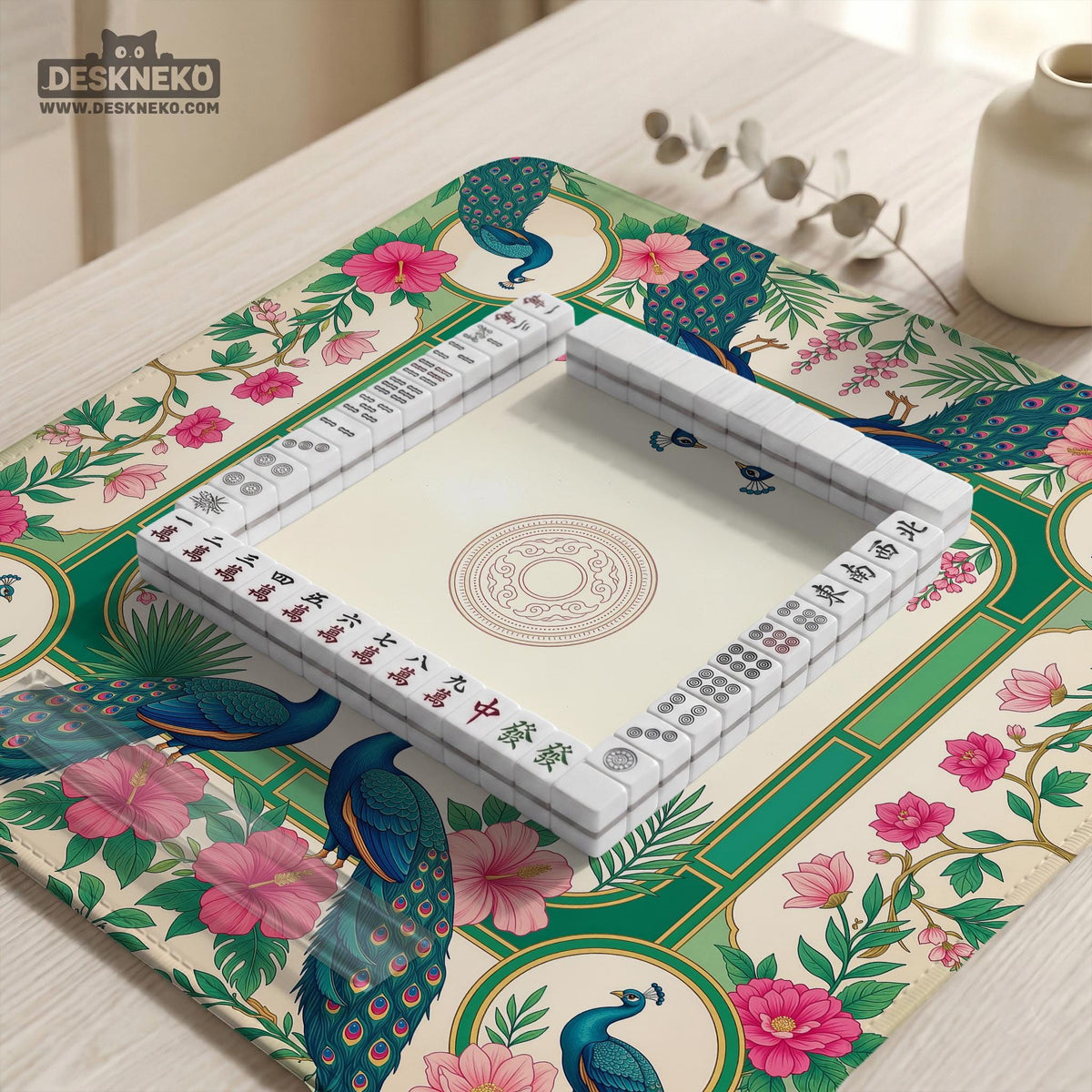 Green mahjong mat with peacocks, hibiscus flowers, tropical leaves, cream center space, and a scalloped floral border.