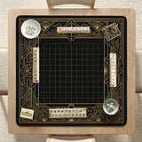 Black and gold square mahjong mat with a scalloped edge, geometric border, thin line details, fan motifs, and dragon and phoenix accents around an open center.