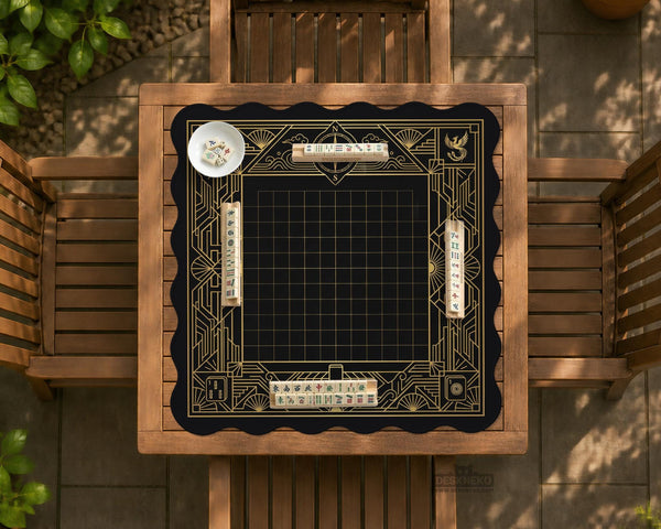 Black and gold square mahjong mat with a scalloped edge, geometric border, thin line details, fan motifs, and dragon and phoenix accents around an open center.