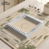 Square mahjong mat with a sage green bamboo and mountain design, cream center, scalloped border details, and gold line accents.