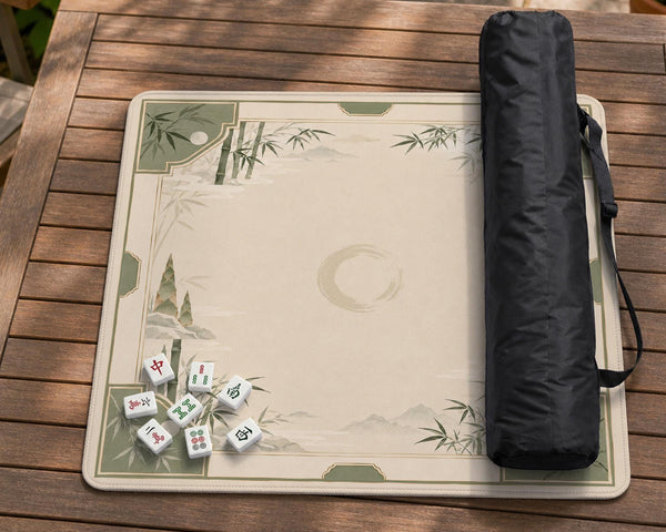 Square mahjong mat with a sage green bamboo and mountain design, cream center, scalloped border details, and gold line accents.