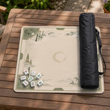 Square mahjong mat with a sage green bamboo and mountain design, cream center, scalloped border details, and gold line accents.