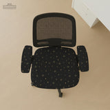 Desk chair cover in black with a small gold star pattern shown on a swivel chair.