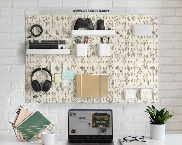 Cream pegboard wall organizer with small floral print, sage green stems, black slot layout, shelves, hooks, clips, and containers.