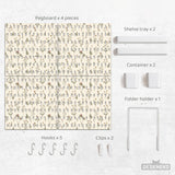 Cream pegboard wall organizer with small floral print, sage green stems, black slot layout, shelves, hooks, clips, and containers.