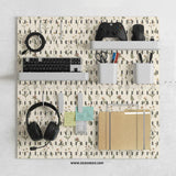 Cream pegboard wall organizer with small floral print, sage green stems, black slot layout, shelves, hooks, clips, and containers.