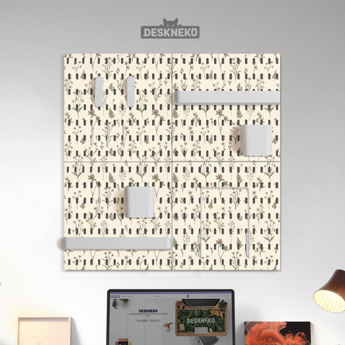 Cream pegboard wall organizer with small floral print, sage green stems, black slot layout, shelves, hooks, clips, and containers.