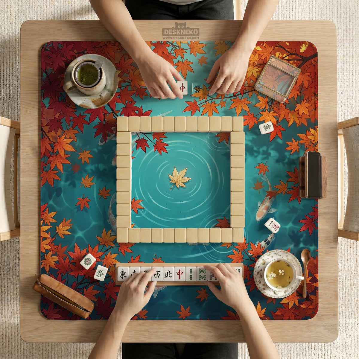 Square teal mahjong mat with koi fish, falling autumn leaves, and pond water artwork.