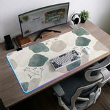 A desk mat with sage green abstract blocks, cream space, gray stone-like shapes, fine topographic contour lines, and small branch details.