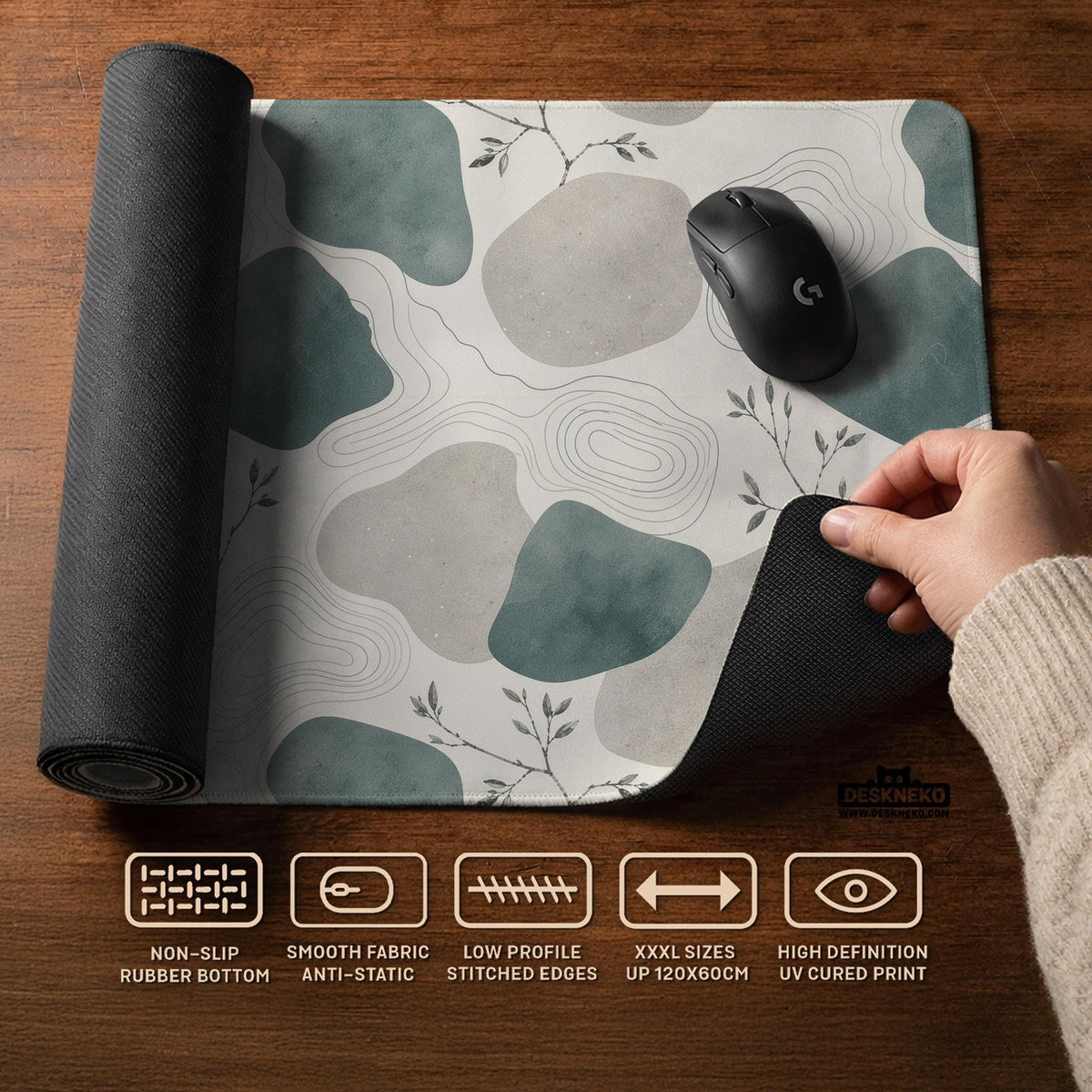 A desk mat with sage green abstract blocks, cream space, gray stone-like shapes, fine topographic contour lines, and small branch details.