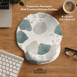 A desk mat with sage green abstract blocks, cream space, gray stone-like shapes, fine topographic contour lines, and small branch details.